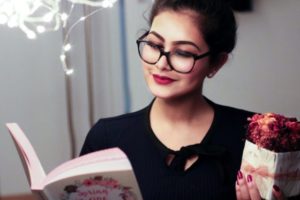 young woman with reading glasses and a book